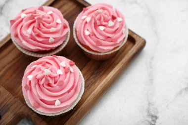 Arkaplanda Sevgililer Günü için lezzetli kekler olan ahşap tahta tahta pano, yakın plan.