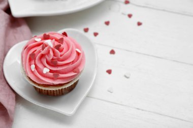 Beyaz ahşap arka planda Sevgililer Günü için lezzetli kek tabağı, yakın plan.