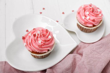 Beyaz ahşap arka planda Sevgililer Günü için lezzetli kekler, yakın plan.