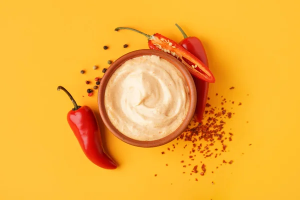 Stock image Bowl of tasty chipotle sauce and fresh jalapeno peppers on color background