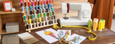 Atölyede dikiş makinesi, malzeme ve eskizlerle terzinin işyeri