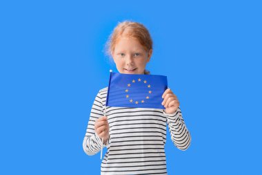 Mavi arka planda Avrupa Birliği bayrağı taşıyan küçük kız