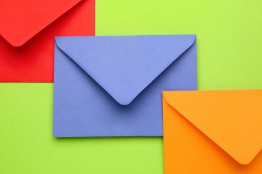 Renk arkaplanı üzerinde farklı kağıt zarflar, yakın plan