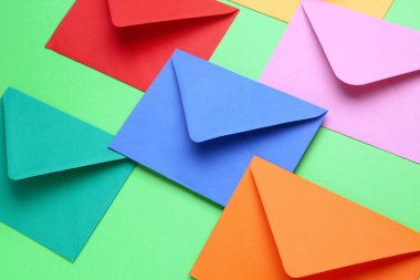 Renk arkaplanı üzerinde farklı kağıt zarflar, yakın plan