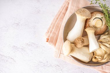 Hafif arka planda bir kase taze mantar.