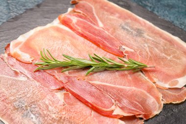 Lezzetli jambon ve biberiye dilimli tahta, yakın plan.