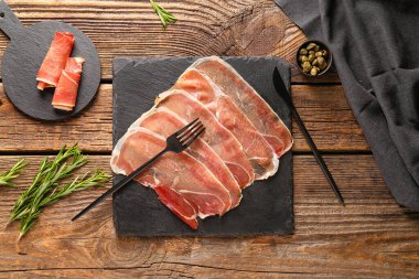 Lezzetli jambon, biberiye ve ahşap kapari dilimli tahta tahtalar.