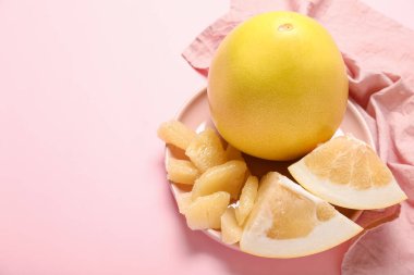 Pembe arka planda meyve ve dilimli tabak, yakın plan.