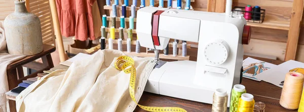 Atölyede dikiş makinesi, giysi ve malzeme ile terzinin işyeri