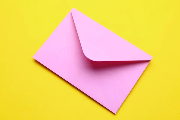 黄色の背景にピンクの封筒 — ストック写真