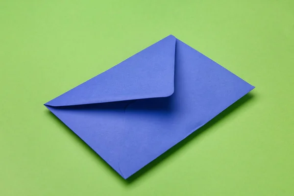 緑の背景に青い紙の封筒 — ストック写真