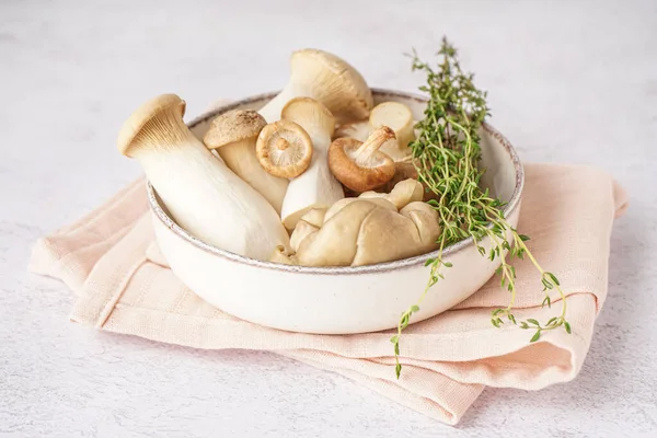 stock image Bowl of fresh mushrooms and thyme on light background