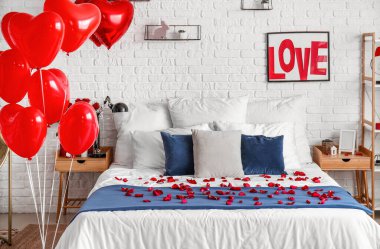 Sevgililer Günü için süslenmiş aydınlık yatak odasının içi güller, kalpler ve balonlarla süslenmiş.