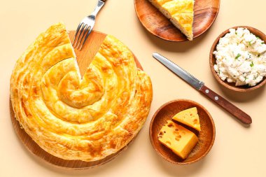 Bej arkaplanlı lezzetli peynirli turta.