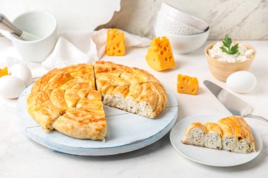 Beyaz masanın üzerinde lezzetli peynirli turta parçaları var.