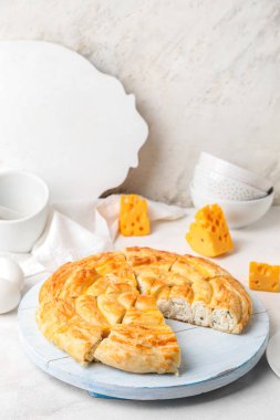 Beyaz masanın üzerinde lezzetli peynirli turta parçaları olan tahta.