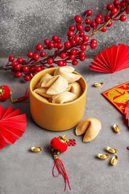 Bir kase fal kurabiyesi ve arka planda Çince semboller. Yeni yıl kutlaması