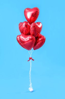Mavi arka planda Sevgililer Günü için kalp şeklinde balonlar.