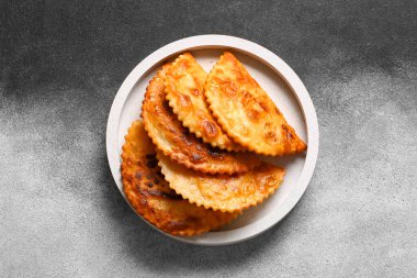 Grunge arka planında lezzetli chebureks içeren beyaz tabak