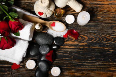 Sevgililer Günü için koyu ahşap arka planda taşlar, mumlar ve güllerle spa kompozisyonu