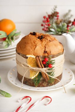 Lezzetli Panettone tabağı ve beyaz masada Noel süsü, yakın plan.