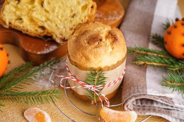Lezzetli Panettone, mandalinalar ve noel dalları bej masa, yakın plan