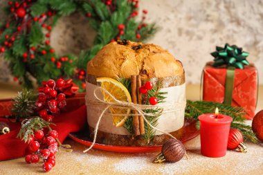 Lezzetli Panettone tabağı, hediyeler ve bej masa üzerindeki Noel dekoru, yakın plan.