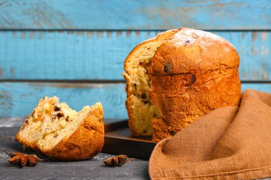Kesilmiş Panettone tahtası ve renkli ahşap arka planda anason