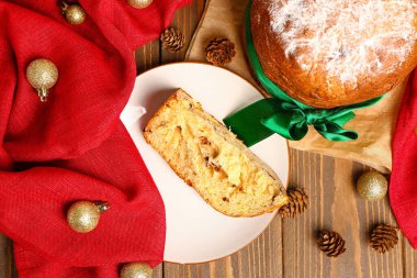 Tabakta Panettone, peçete ve Noel topları var.