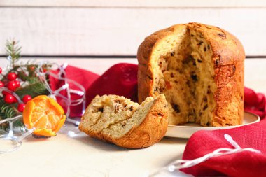 Panettone 'u mandalina ve Noel dekoruyla aydınlatma masasında kes, kapat