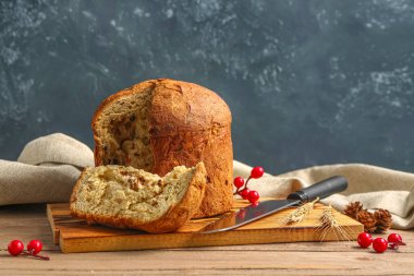 Panettone ve bıçaklı tahta karanlık duvarın yanında.
