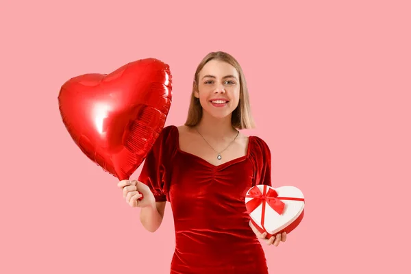 有心形气球和粉色背景的礼物的年轻女人 情人节庆祝活动 — 图库照片