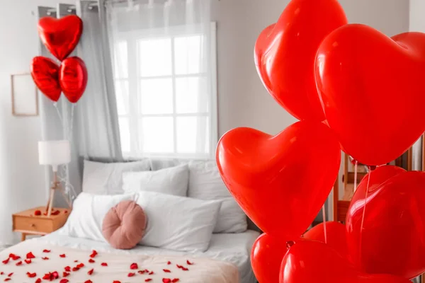 Heart shaped balloons in light bedroom decorated for Valentine\'s Day, closeup