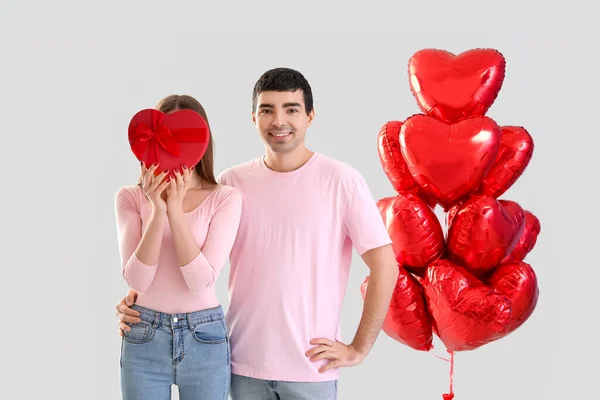 年轻夫妇喜欢礼物和浅色背景的气球 情人节庆祝活动 — 图库照片