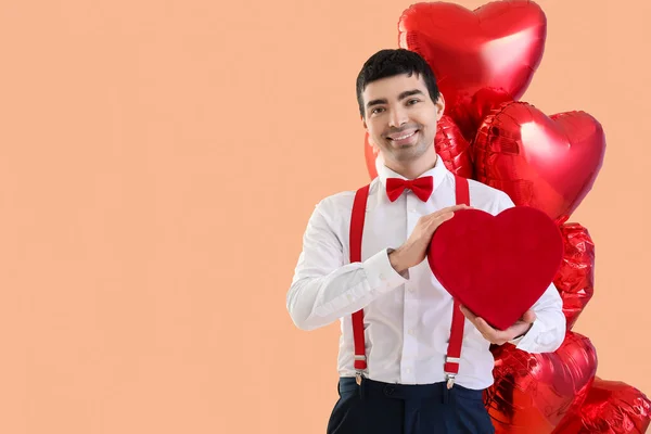 Молодий Чоловік Подарунком Кульками Бежевому Фоні День Святого Валентина — стокове фото