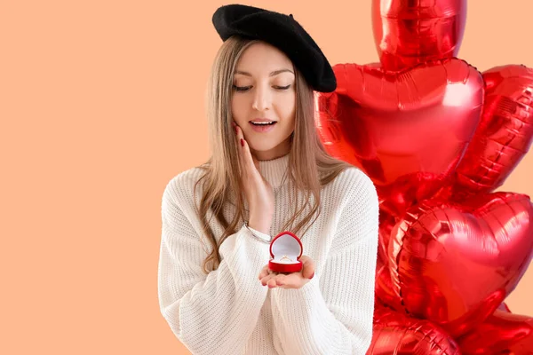 带着订婚戒指和米色背景气球的年轻女人 情人节庆祝活动 — 图库照片