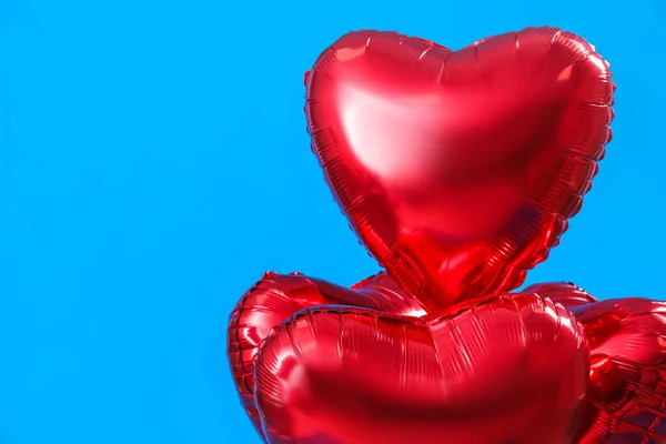 Heart-shaped balloons for Valentine\'s Day on blue background