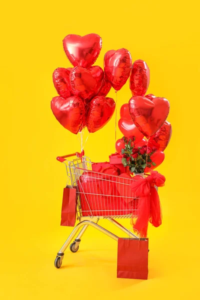 Купівля Візка Подарунками Трояндами Кульками Жовте Тло — стокове фото