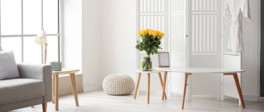 İçinde güzel sarı güller olan bir vazo.