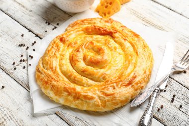 Lezzetli peynirli turta, biberli mısır ve beyaz ahşap arka planda malzemeler.