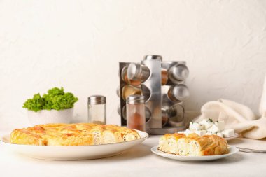 Lezzetli peynirli turta ve beyaz masadaki malzemeler.