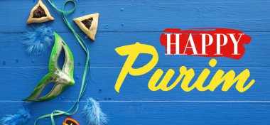 Beautiful greeting card for Happy Purim with Hamantaschen cookies and carnival mask on blue wooden background