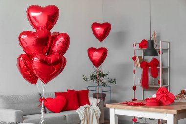 Interior of dining room decorated for Valentine's Day with table, sofa and balloons