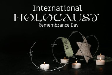 David star, barbed wire and burning candles on dark background. International Holocaust Remembrance Day