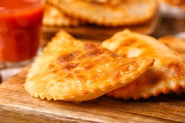 Masada lezzetli cheburekler olan tahtayı kesme, yakın plan.