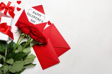 Yazılı kart Mutlu VALENTINE Günü, güller, zarflar ve beyaz arkaplanda hediyeler