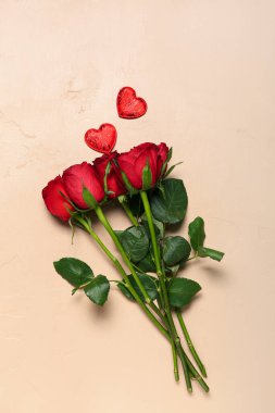 Kırmızı güller ve bej arka planda kalpler. Sevgililer Günü kutlaması