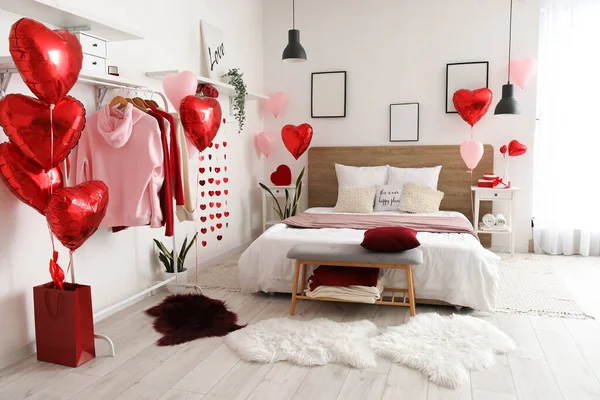Interior of bedroom with clothes and balloons for Valentine\'s Day
