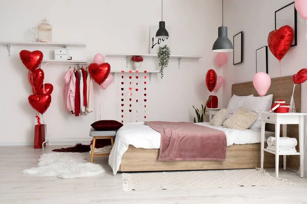 Interior of bedroom with clothes and balloons for Valentine\'s Day