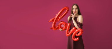 Balon şeklinde balonu olan güzel bir genç kadın. Renkli arka planda aşk var. Sevgililer Günü kutlaması